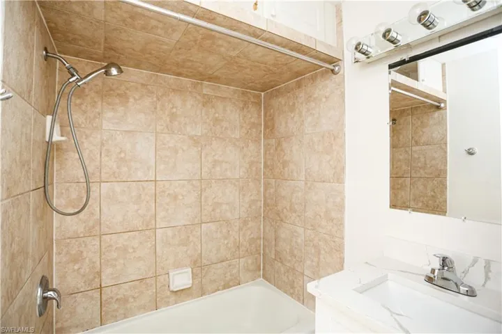Bathroom with vanity and tiled shower / bath