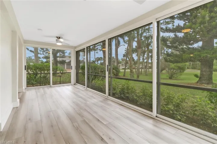 Unfurnished sunroom with ceiling fan and plenty of natural light