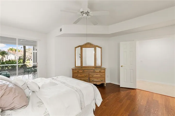 Bedroom with access to outside, dark wood finished floors, and a ceiling fan