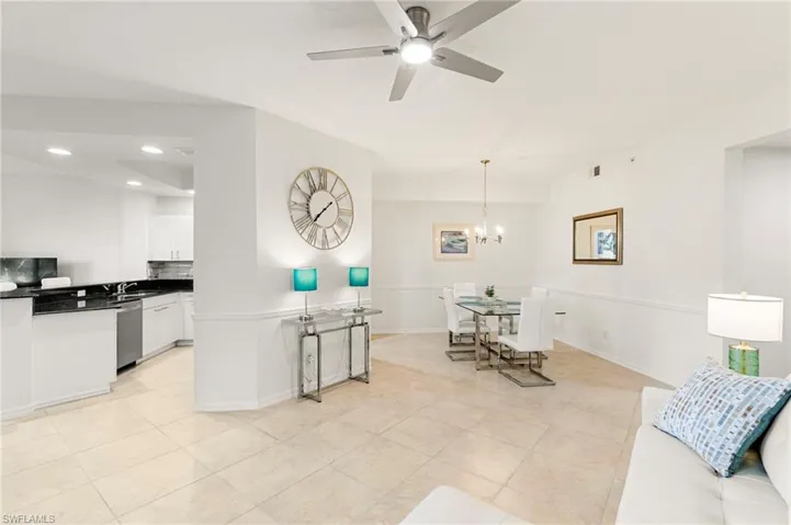 Living room featuring ceiling fan, light tile patterned floors, and hanging lights