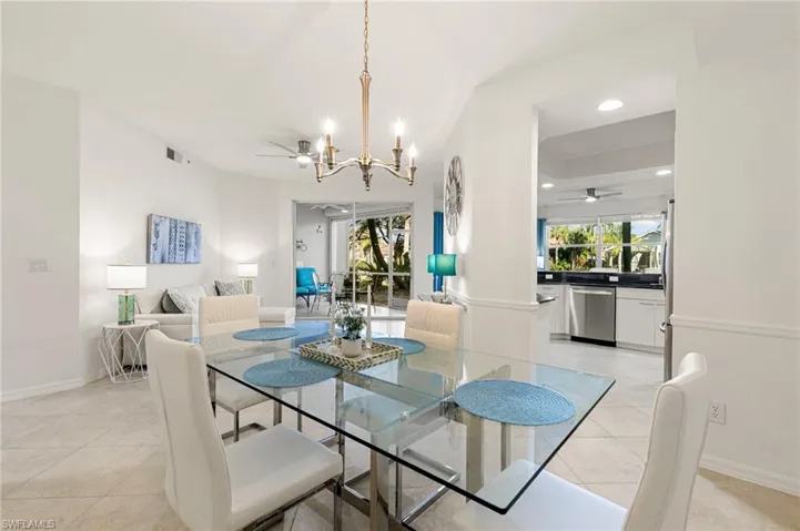 Dining area with a ceiling fan, suspended lighting, and light tile patterned floors