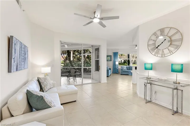 Living room featuring light tile patterned floors and ceiling fan