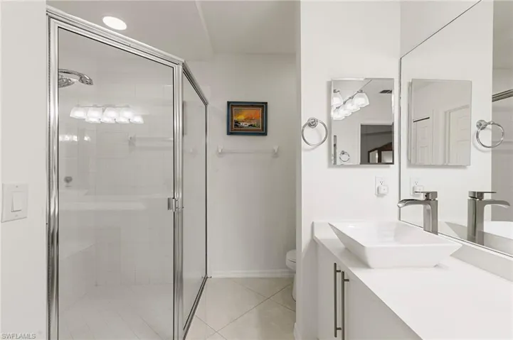 Bathroom featuring vanity, a stall shower, and light tile patterned floors