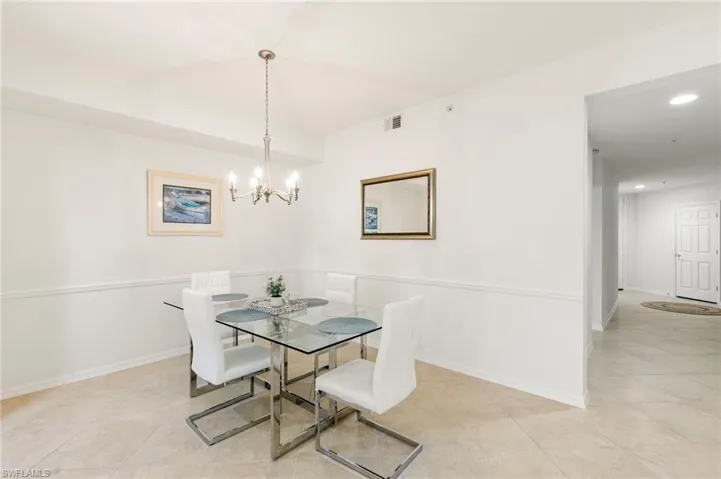 Dining room with hanging lights and light tile patterned floors