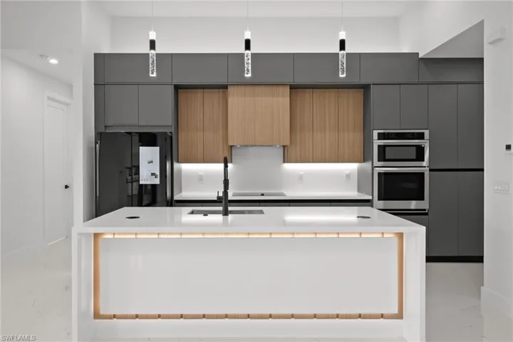 Kitchen with freestanding refrigerator, modern cabinets, light countertops, gray cabinetry, and recessed lighting