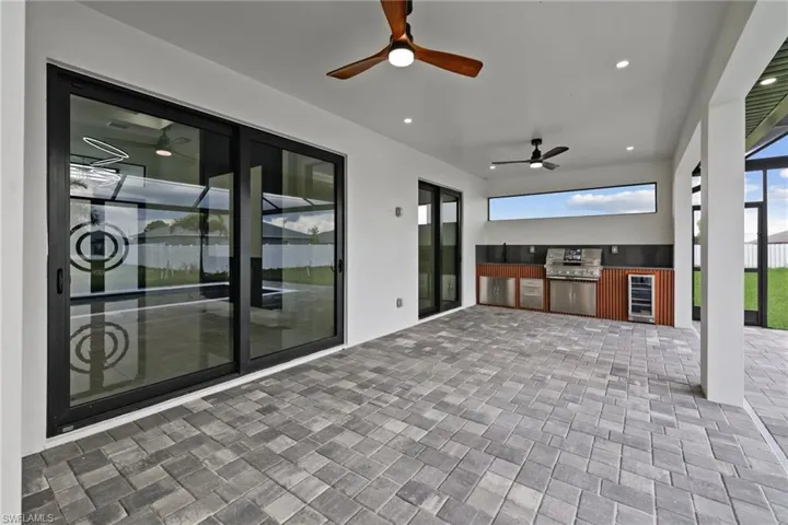View of patio with wine cooler, a ceiling fan, and exterior kitchen