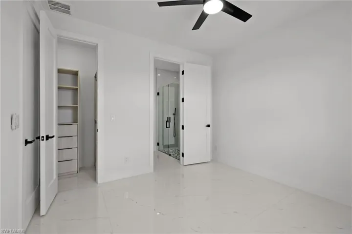 Unfurnished bedroom featuring light marble finish flooring and a ceiling fan