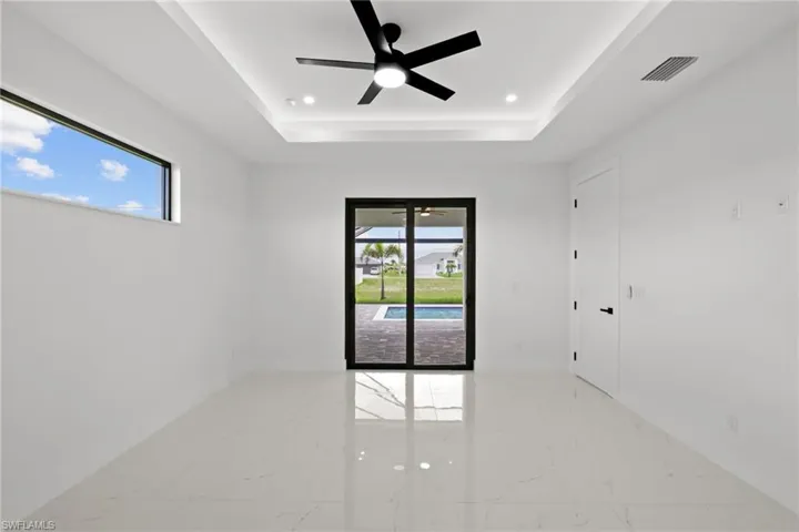 Unfurnished room with marble tiled floors, a tray ceiling, a ceiling fan, and recessed lighting