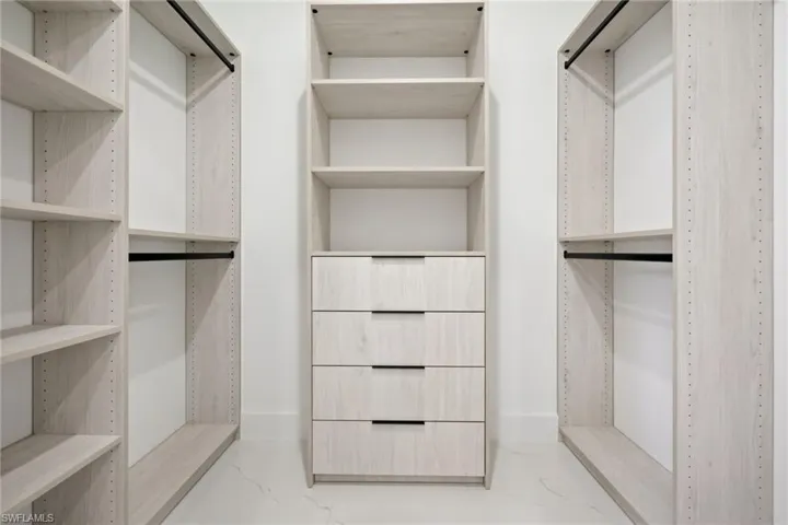 Walk in closet with marble finish floors