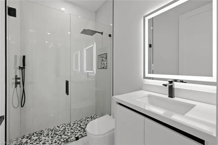Full bath with a shower stall and vanity