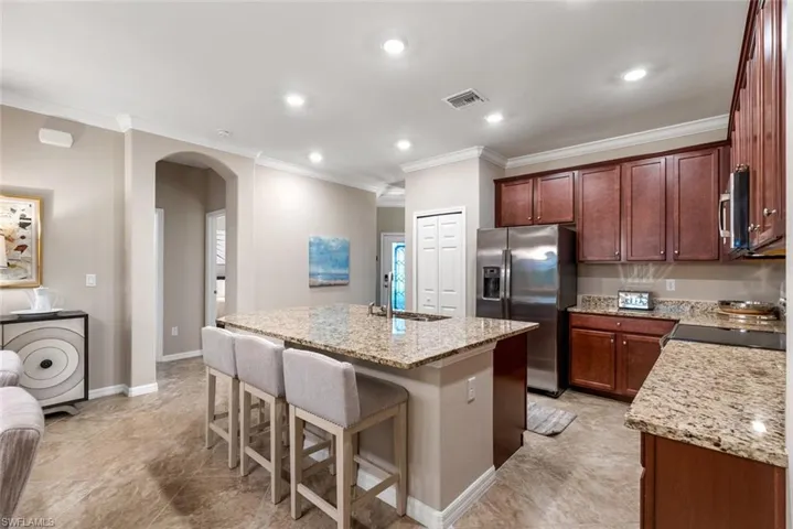 Kitchen featuring stainless steel appliances, kitchen island with sink and breakfast bar