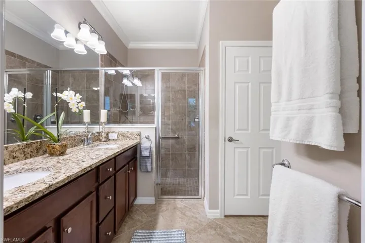Master Bathroom featuring walk in shower, linen closet, and double vanity