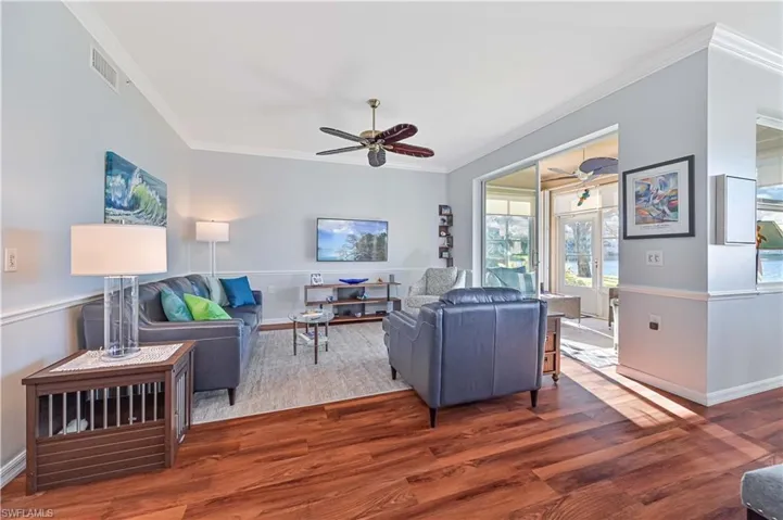 Living room featuring ceiling fan, dark hardwood / wood-style floors, and ornamental molding