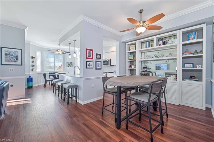 Dining space with crown molding, sink, ceiling fan, and dark hardwood / wood-style floors