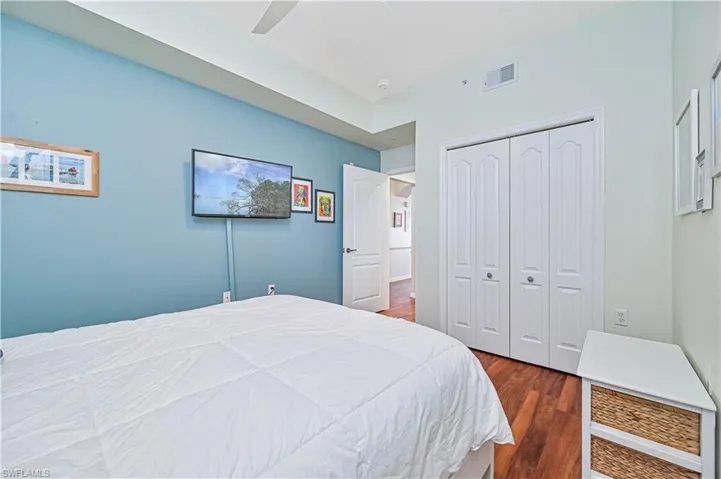 Bedroom with ceiling fan, a closet, and dark hardwood / wood-style floors