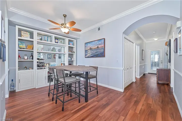 Dining space featuring dark hardwood / wood-style flooring, ceiling fan, and ornamental molding