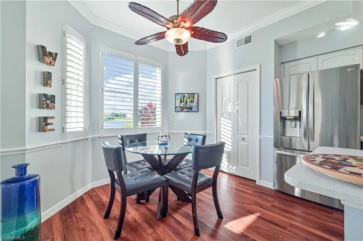 Dining room featuring crown molding, ceiling fan, and dark wood-type flooring