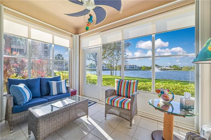 Sunroom / solarium with ceiling fan and a water view
