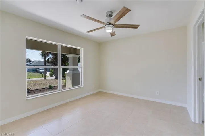 Spare room featuring ceiling fan and light tile patterned floors