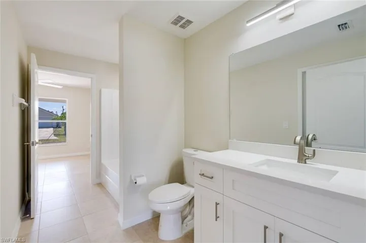 Full bath featuring vanity and light tile patterned flooring