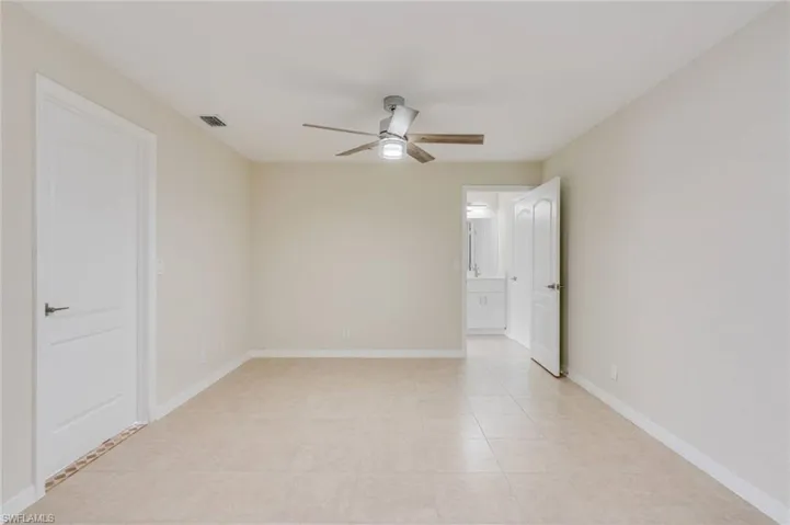Empty room with baseboards and a ceiling fan