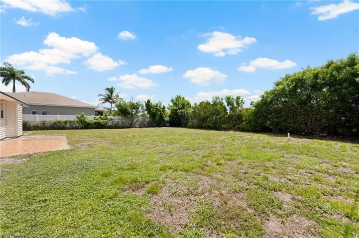 Expansive grassy yard with mature perimeter foliage