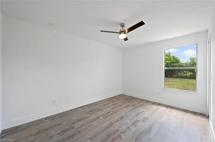 Room featuring light wood-finish flooring, white baseboards, and a contemporary ceiling fan with integrated lighting