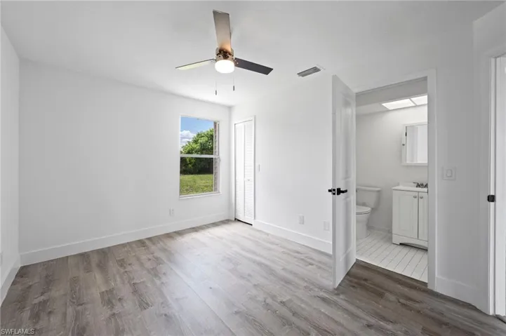Room featuring wood-finish flooring, white baseboards, and a ceiling fan with integrated lighting
