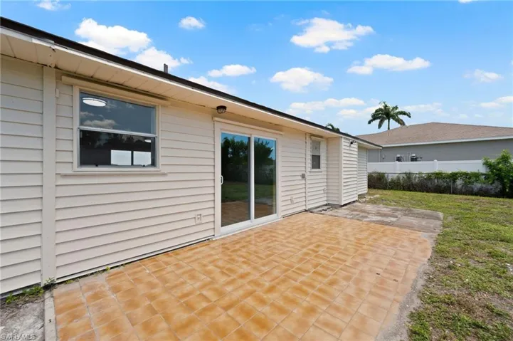 Exterior patio featuring terracotta-toned tile and a sliding glass door