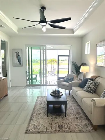Living area with tray ceiling,  ceiling fan from Dan's Fans, Upgraded tile, plantation shutters & tv mount