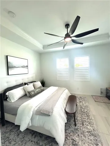 Primary bedroom with custom barn door, upgrades: tray ceiling, ceiling fan from Dan's Fans & plantation shutters & carpet