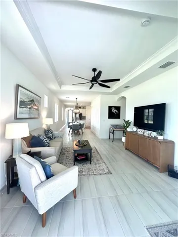 Living area with tray ceiling,  ceiling fan from Dan's Fans, Upgraded tile, plantation shutters & tv mount