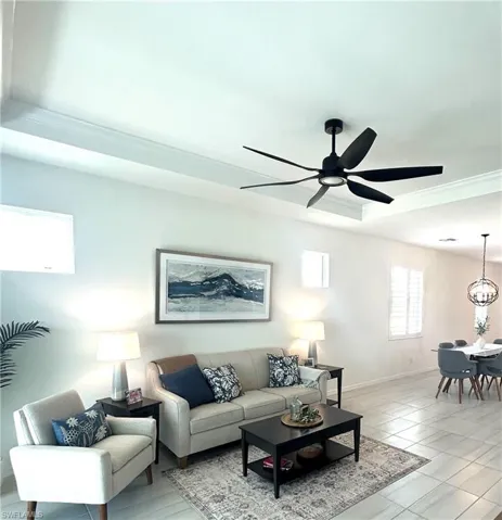 Sun filled living area with tray ceiling,  ceiling fan from Dan's Fans, Upgraded tile, plantation shutters & tv mount