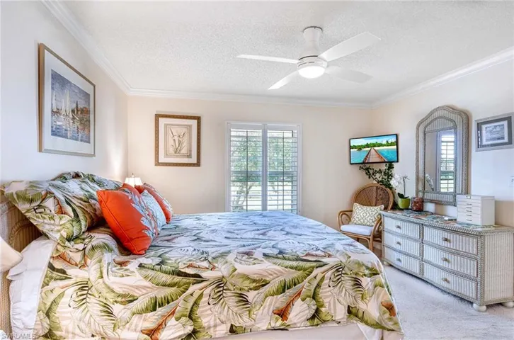 Bedroom featuring crown molding, multiple windows, carpet, a textured ceiling, and a ceiling fan
