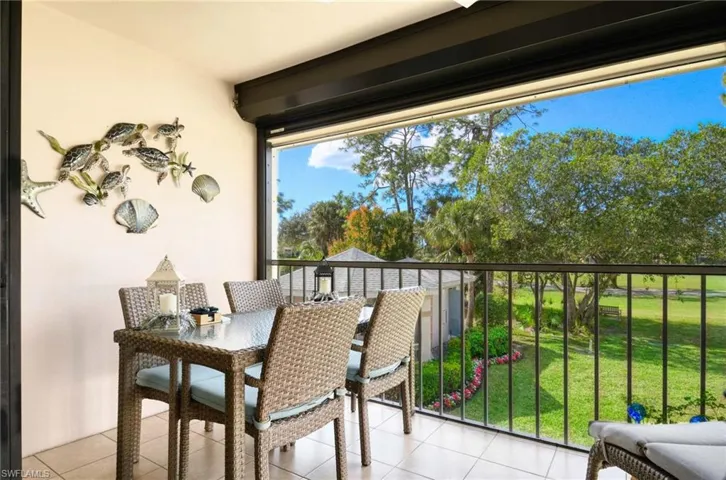 Balcony with a sunroom and outdoor dining area