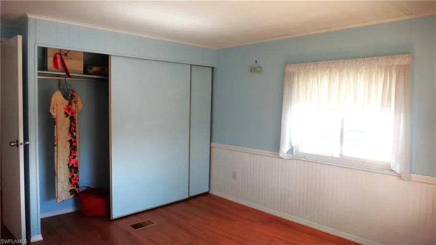 Guest room wood-type flooring, crown molding, and a closet