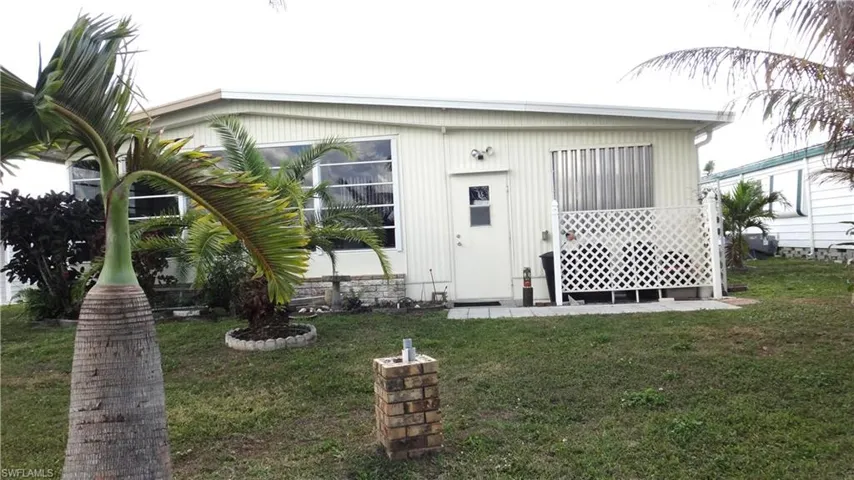 Back of house with a lawn