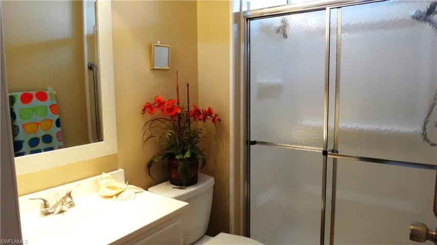 Guest Bathroom featuring walk in shower, vanity, and toilet