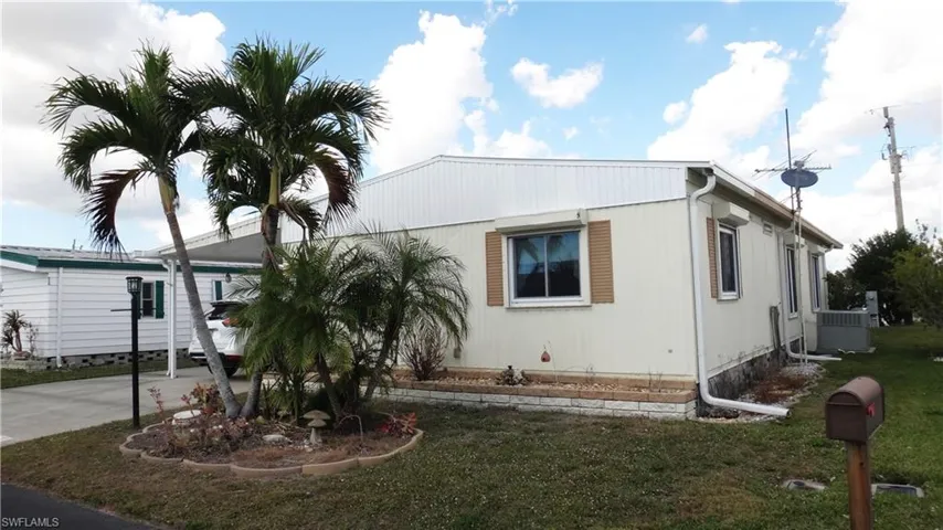 View of front of property featuring a front lawn and eastern side of home.