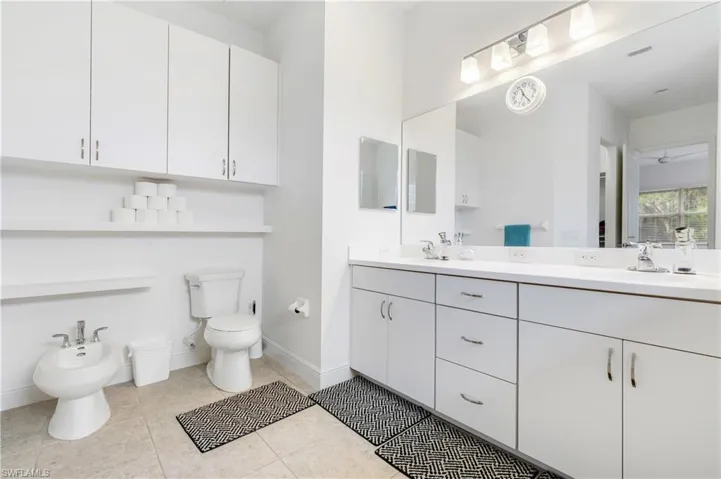Full Primary bathroom with double vanity, a bidet, and light tile patterned flooring