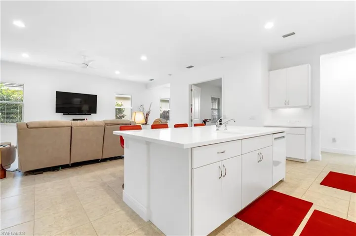 Kitchen featuring white cabinets, recessed lighting, an island with sink, ceiling fan, and open floor plan
