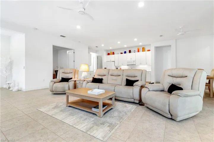 Living room featuring a ceiling fan, recessed lighting, and light tile patterned flooring