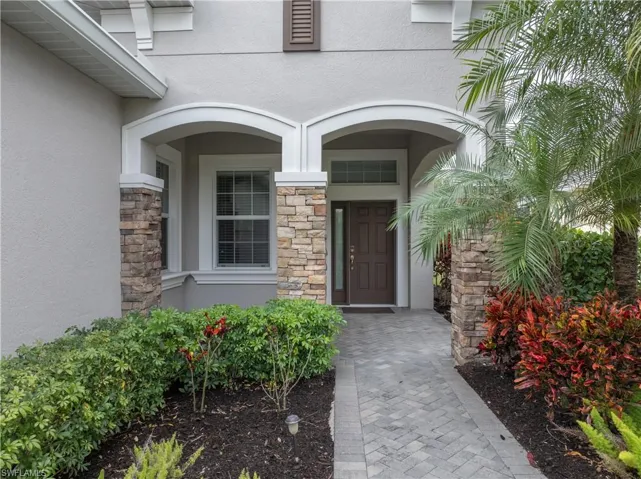 View of exterior entry featuring stone siding and stucco siding
