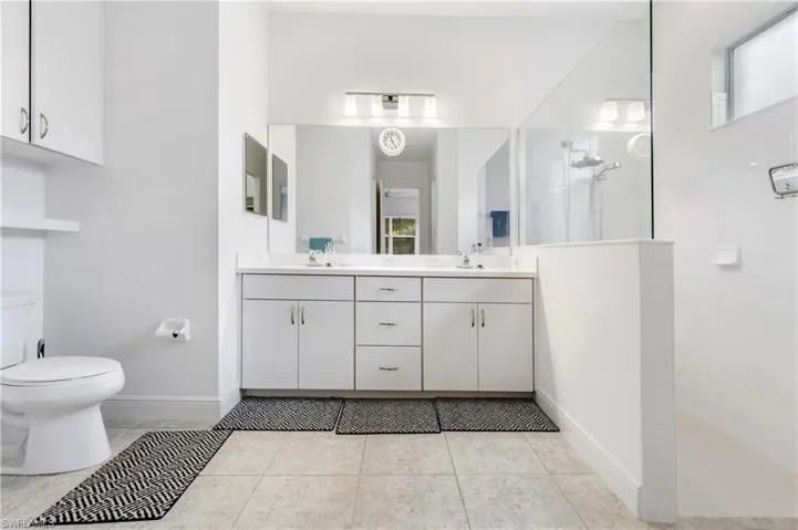 Full Primary bathroom featuring healthy amount of natural light, walk in shower, and double vanity