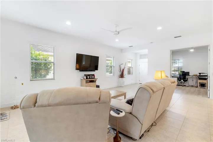 Living area featuring a desk, recessed lighting, light tile patterned floors, and ceiling fan
