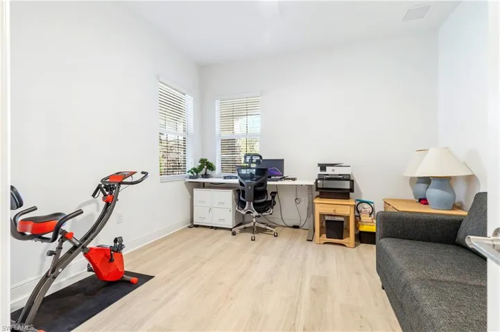 Office area with light wood-style flooring and baseboards