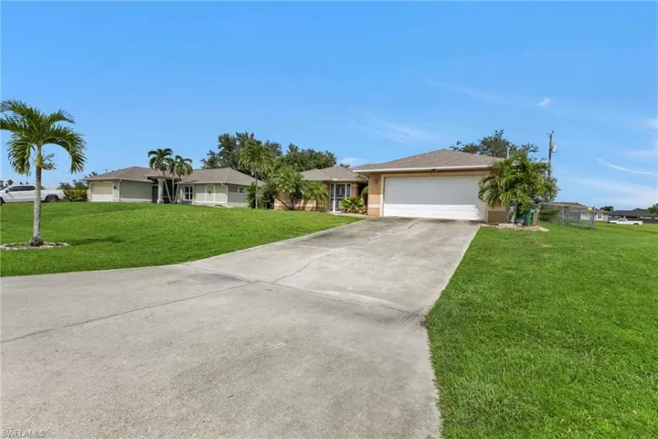Ranch-style house with a front yard and a garage