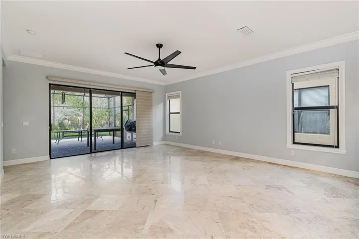 Spare room with ornamental molding, healthy amount of natural light, and ceiling fan