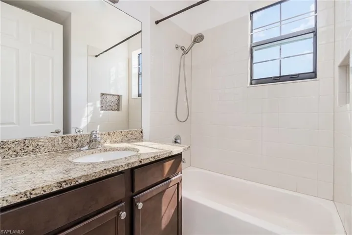 Bathroom featuring vanity and washtub / shower combination