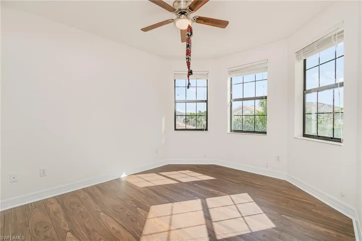 Unfurnished room with dark wood-style floors and ceiling fan